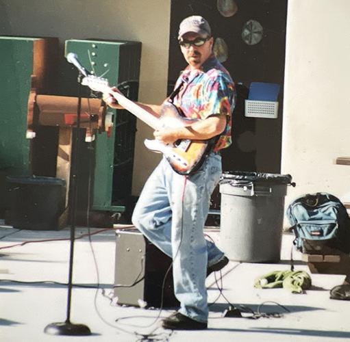 Man in colorful shirt playing electric guitar